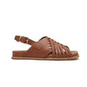 A tan brown leather slide sandal with a wide criss-cross strap design across the foot and a single adjustable ankle strap with a gold-tone buckle, shown in a side profile on a white background. Podiatry endorsed comfort. Minx wellness footbed